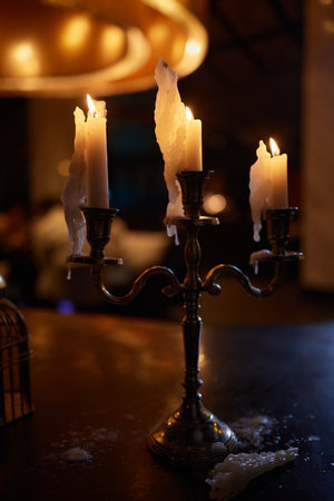 Burning candles on a table in a cozy home close-up on a table in a home interior. Evening romantic...