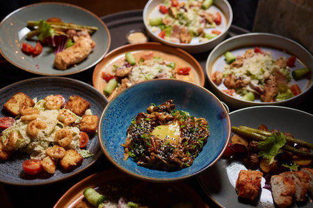 Friends having dinner. Top view of four people having dinner together while sitting at the rustic wooden table.の写真素材