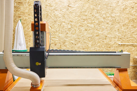 The machine cuts a piece of wood. Close-up. A CNC machine cuts a piece of wood with a cutter. A...