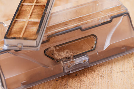 Cleaning the filter of the vacuum robot cleaner from dirt, close-up.