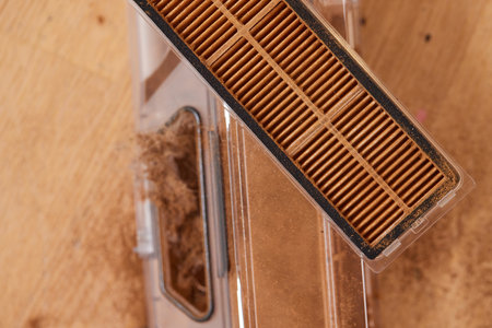 Cleaning the filter of the vacuum robot cleaner from dirt, close-up.の写真素材