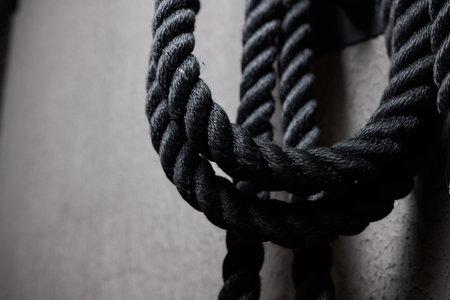 Close up of black battle rope on a gray backgound. Sport and fitness equipment. Functional training.の写真素材
