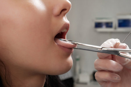 Tongue piercing operation Professional holding the jewel.の写真素材