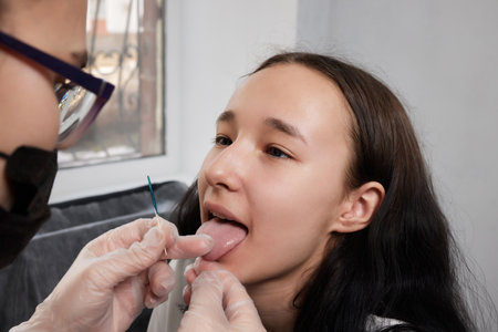 Tongue piercing operation Professional holding the jewel.