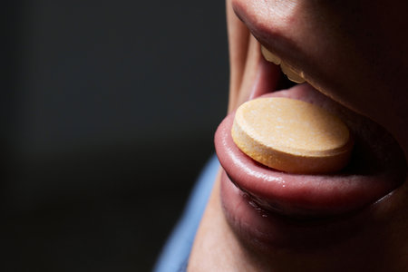 Man taking pill, mouth open with tongue sticking out.の写真素材