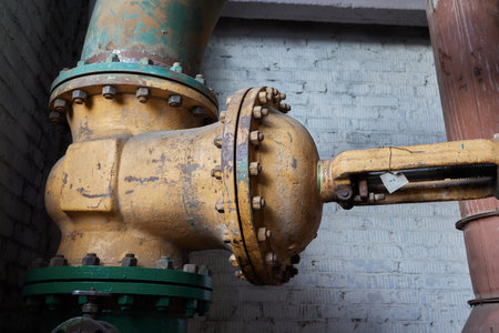 Close-up at pipeline valve which is using to control production process in the oil refinery plant. Selective focus at the valve handle wheel, Heavy industrial object photo.の写真素材