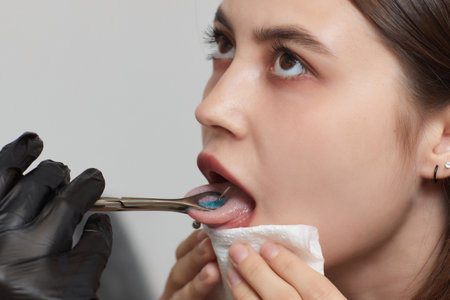 Tongue piercing operation Professional holding the jewel.の写真素材