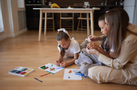 Two preschoolers playing with colorful plasticine and having fun. Focus on the girl on the right.