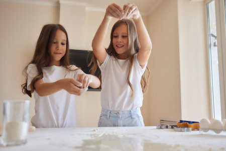 little girl is helping to bake in a messy kitchen.
