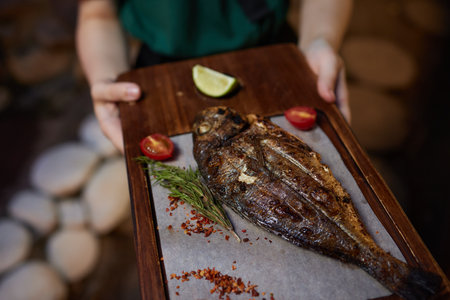 Tray with tasty grilled dorado fish on wooden backgroundの写真素材