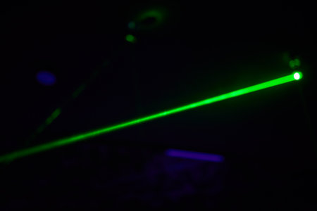 Bright green neon laser lights illuminate the darkness creating lines and triangle shapes in sci-fi effect.の写真素材