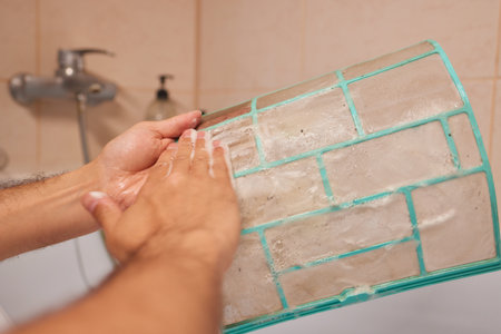 Washing air-conditioner filter with waterの写真素材
