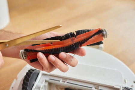 robot vacuum cleaner brush clogged with hair and dustの写真素材