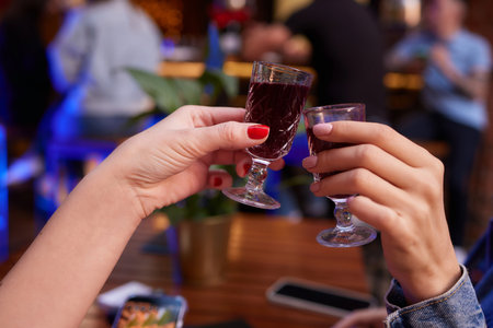 people at the bar try tinctures, red tinctures in glasses, alcoholic shots.の写真素材