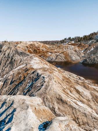 Clay Open Quarry Mars Landscape with Orange Water. Abandoned Rock Texture Old Porcelain Pit Mine in Ural. Erosion Crack Hill Desert Surface.の写真素材