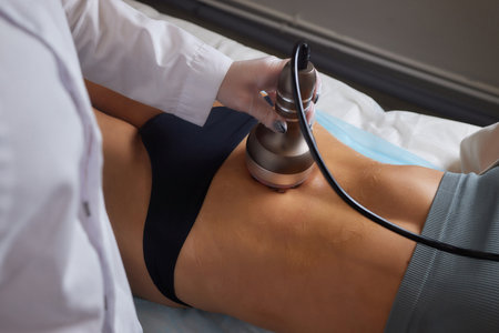 procedure removing cellulite on female abdomen, cavitation belly massage. Ultrasonic massage for weight loss. Correction of female figure without surgical intervention. Closeup of the tummy.の写真素材