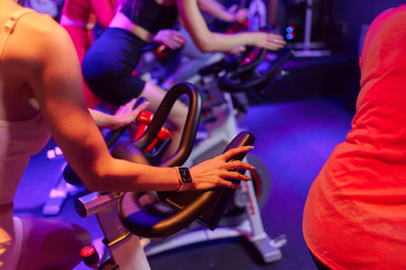 Group fitness riding a exercise bikes. Three athletes girlfriend pedaling on a stationary bike at...