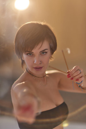 Beautiful mindfulness young girl relaxing and enjoying incense stick after yoga class.