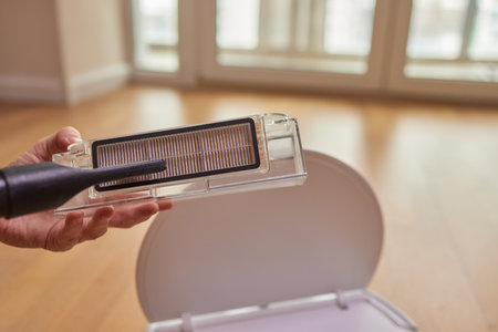 Cleaning the filter of the vacuum robot cleaner from dirt, close-up.