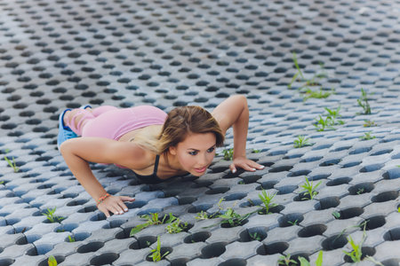 Attractive and strong woman stretching before fitness in the summer park. Sports concept. Healthy...