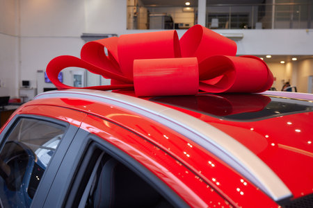 The new car is wrapped in a red bow. Beautiful gift concept.の写真素材