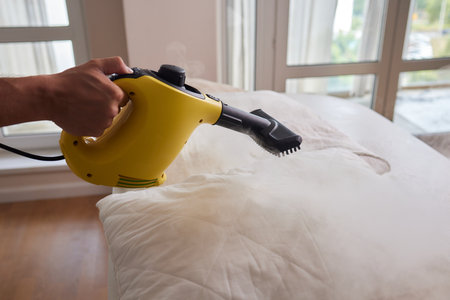 Using dry steam cleaner to sanitize pillow.の写真素材