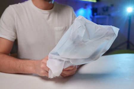 Man in black uniform unpacking a retail box.の写真素材
