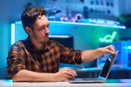 Young man using laptop in room at home