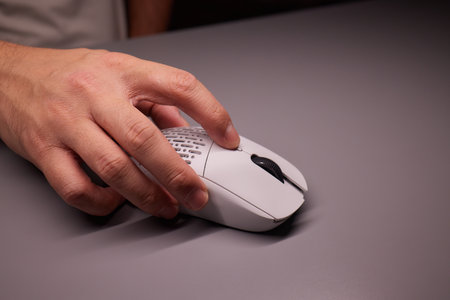 Close-up Macro Shot: Persons Hand Using Wireless Computer Mouse, Scrolls through Apps and Websites with a Wheel and Clicks on Buttonsの写真素材
