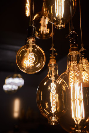 Decorative incandescent bulbs in Edison style on a brick wall background.