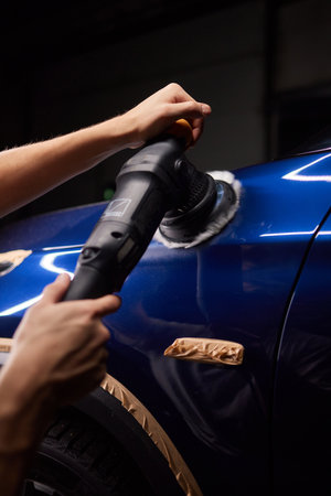 Car detailing - Man with orbital polisher in repair shop polishing car. Selective focusの写真素材