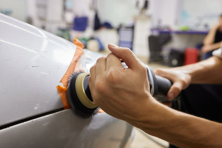 Big headlight cleaning on the car with power buffer machine at service station ,Before and after cleaningの写真素材