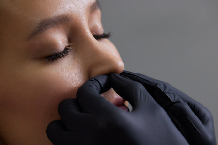 Closeup of a young womans visage with piercing septum hanging from her nose.の写真素材
