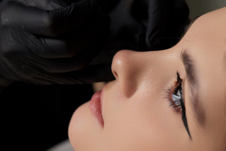 Closeup of a young womans visage with piercing hanging from her nose.の写真素材