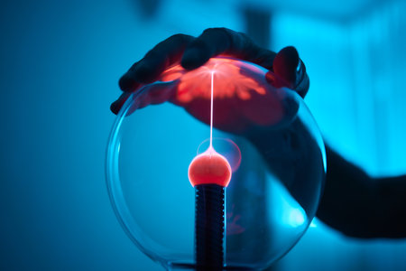 plasma ball. Hands holding plasma light ball. Plasma ball light ray science. Finger touching Plasma ball with smooth magenta blue flames. Electromagnetic Fields in a glass globe.の写真素材