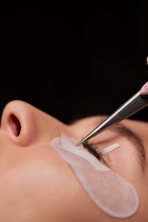 Eyelash Extension Procedure. Woman Eye with Long Eyelashes. Lashes, close up, macro, selective focus.の写真素材
