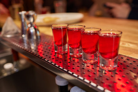 Bartender pouring and serving alcoholic drinks at bar