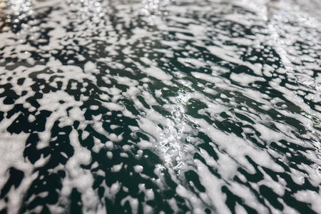Car wash. leaning automobile with foam, close-up.の写真素材
