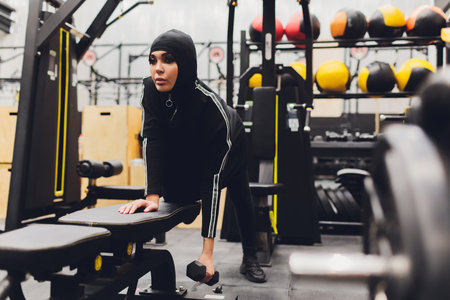 Muslim asian woman in hijab exercizing in a gym.の写真素材
