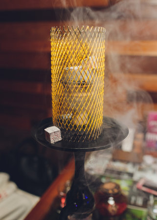 Top of the hookah with glowing hot coal and on the background.
