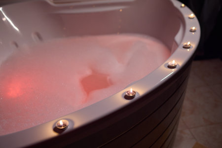Enjoy a relaxing bubble bath in a luxurious setting with soft, soothing candlelightの写真素材