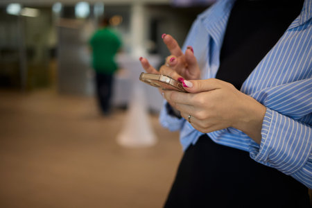 Woman in stylish dress with chic manicure using smartphone in closeup shot