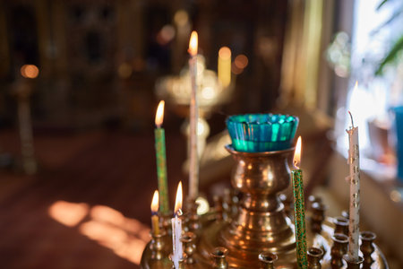 An Ornate Gold Cross Encircled by Colorful Candles Within a Beautiful Church Interiorの写真素材