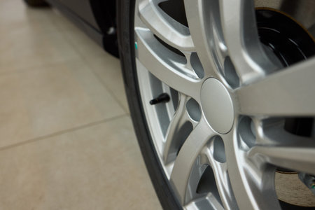Detailed shot of a sleek black and silver alloy wheel on a motor vehicle