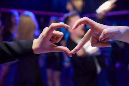 Hands Forming a Heart Shape in the Midst of a Vibrant and Joyful Celebration Eventの写真素材