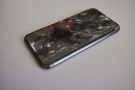 Broken phone screen in hand