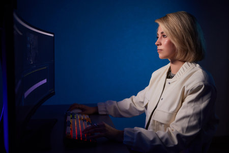 Beautiful Female Video Editor Works with Footage on Her Personal Computer, She Works in Creative Office Studio.の写真素材