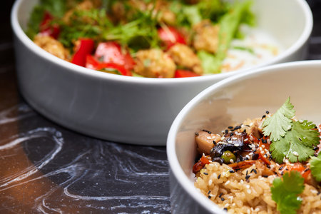 Close up of three bowls with fish ball, leaf vegetable, and plate on tableの写真素材