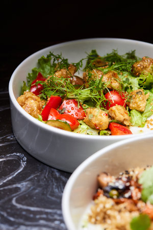 Close up of three bowls with fish ball, leaf vegetable, and plate on tableの写真素材