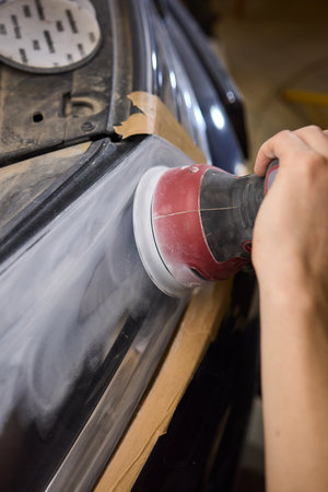 Person using a machine to polish automotive lighting on a car headlightの写真素材